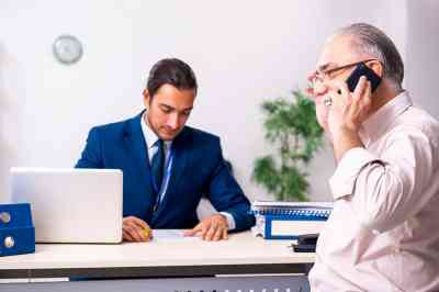 Pensionist telefoniert, Sachbearbeiter am Schreibtisch - © Elnur - stock.adobe.com